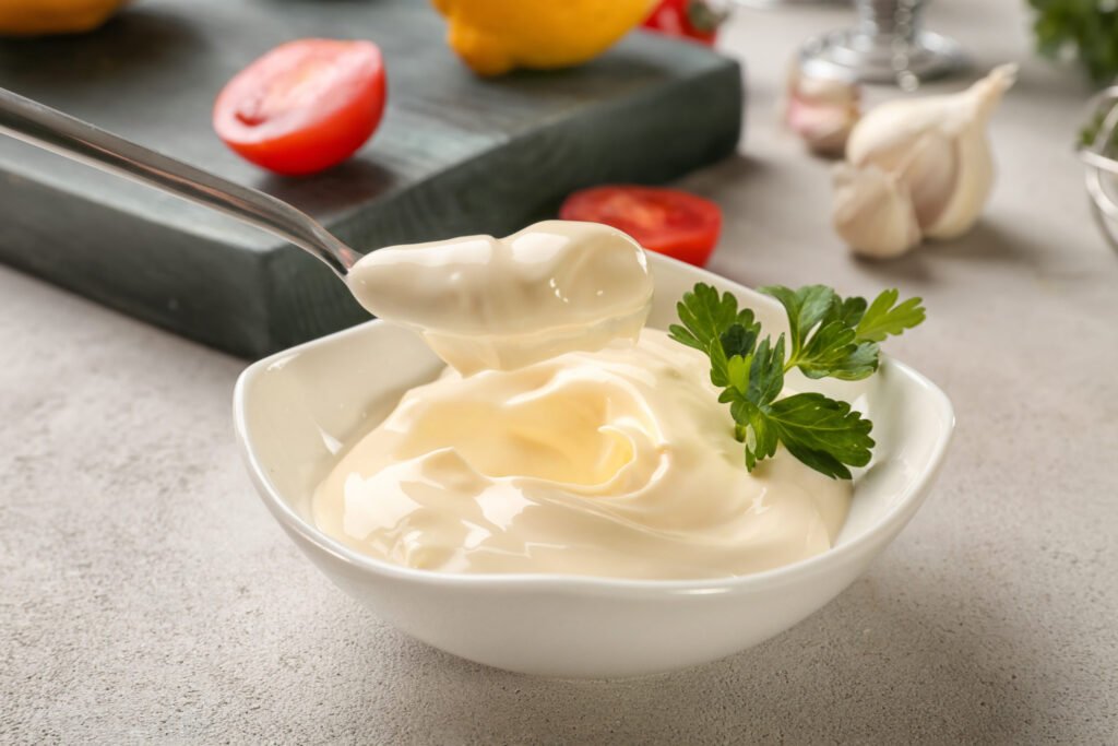 Delicious,Mayonnaise,In,Bowl,And,Spoon,On,Kitchen,Table,,Closeup